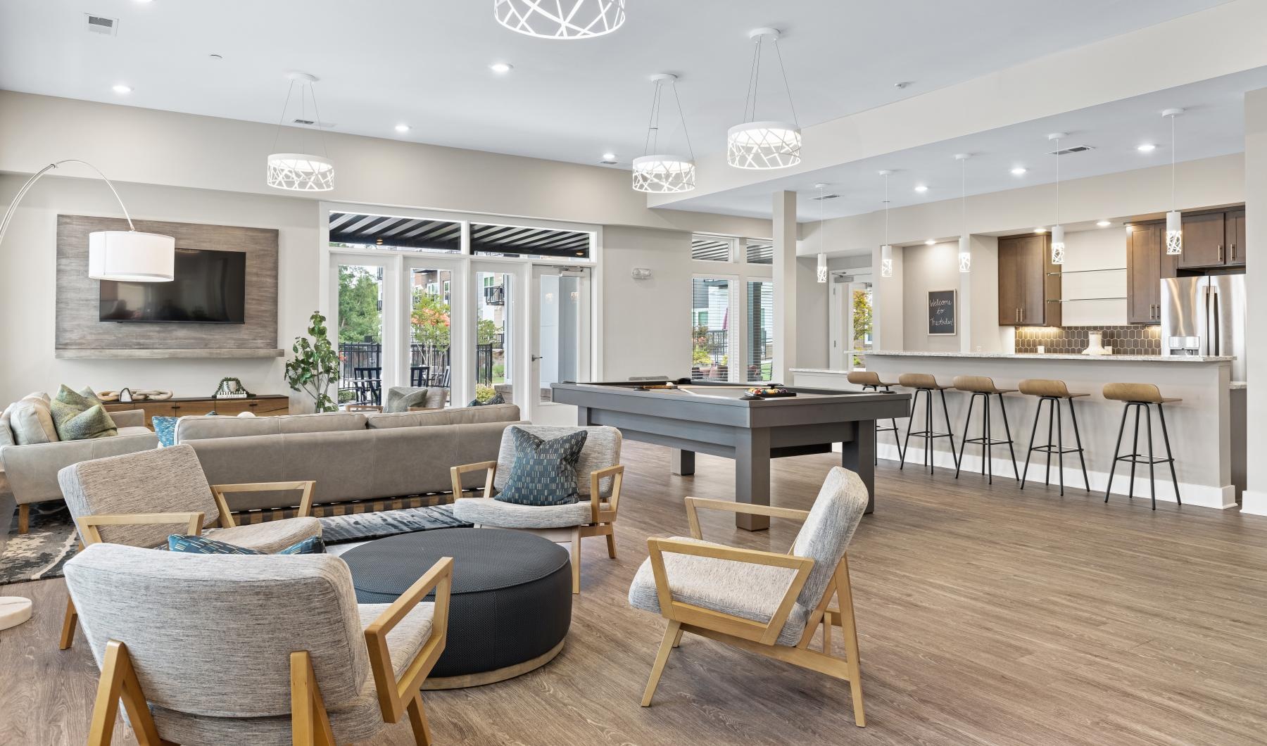 State-of-the-art amenities a clubroom with a couch, a pool table and chairs