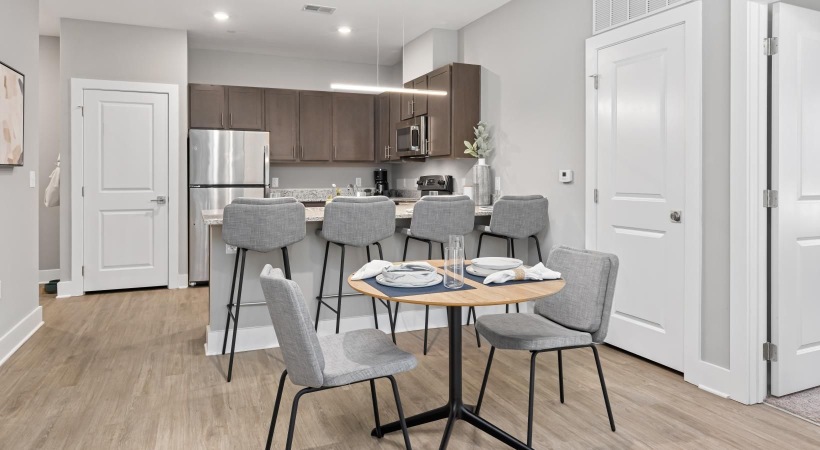 Spacious kitchens with thoughtful details a kitchen with a dining table and chairs