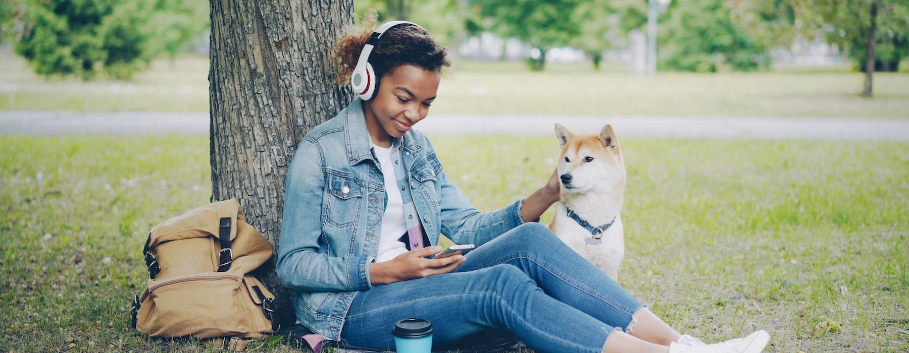 a girl and a dog sitting under a tree